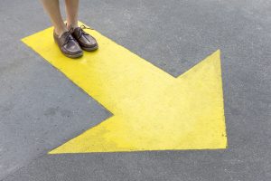 man standing on arrow